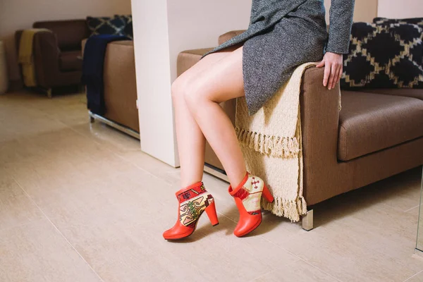 Look kbook woman 's legs in red leather boots in the interior — стоковое фото