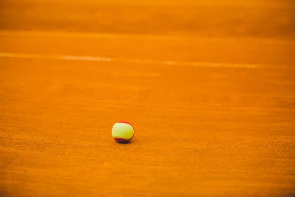 Rode tennisbal op een klei tennis court oranje kleur — Stockfoto