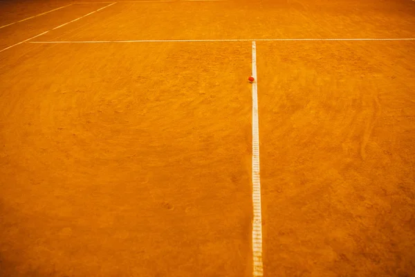 Röd tennisboll på en lera tennis domstolen orange färg — Stockfoto