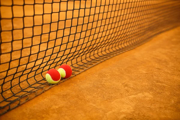 Rode tennisbal op een klei tennis court oranje kleur — Stockfoto