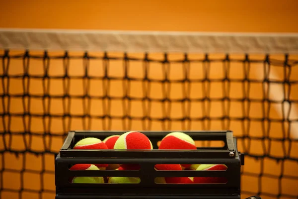 Un montón de pelotas de tenis a pelotas de canasta, pista de tenis. Rejilla para tenis — Foto de Stock