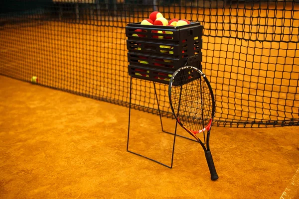 Mnoho tenisových míčků na Basketbalové míče, tenisový kurt. Mřížka pro tenis — Stock fotografie