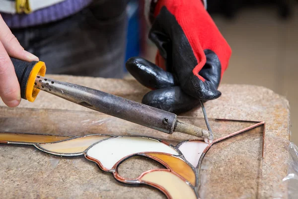 Stained glass maker works with souvenirs