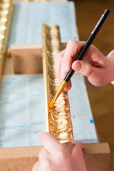 Pittura a mano femminile con pennello baguette per soffitto in colore oro — Foto Stock