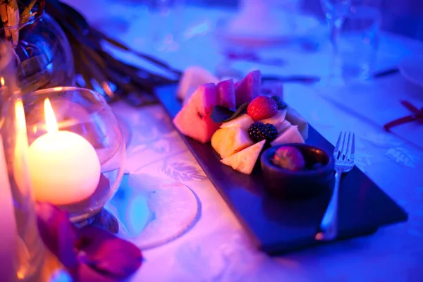 Strawberries, blueberries on the table in the restaurant by candlelight — Stock Photo, Image