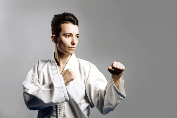 Chica, Taekwondo es marcial Stoke manos en puños, enfocado, mirada seria en el estudio sobre fondo aislado gris — Foto de Stock
