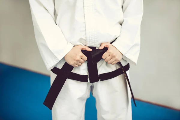 Hands on the black belt and kimono. the martial art of Tae Kwon do and karate. — Stock Photo, Image