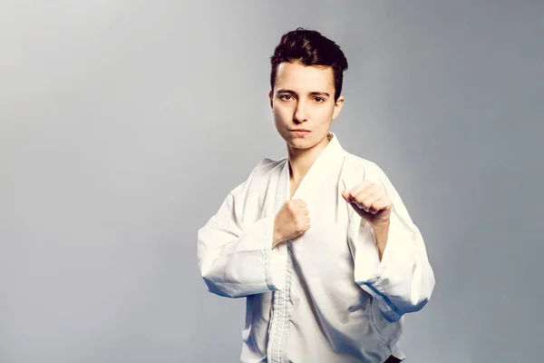 Chica, Taekwondo es marcial Stoke manos en puños, enfocado, mirada seria en el estudio sobre fondo aislado gris —  Fotos de Stock