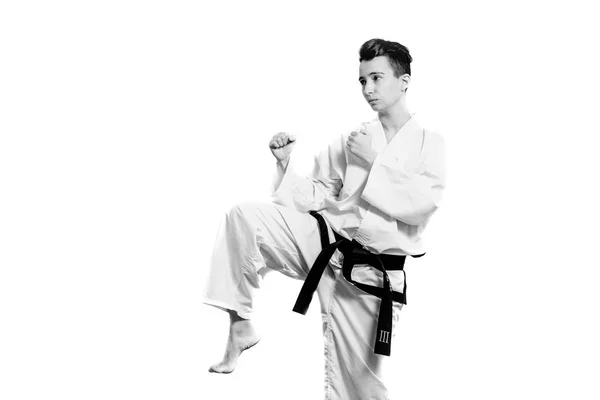 Chica en traje de karate kimono en estudio en fondo gris. La niña muestra judo o karate stans en uniforme blanco con cinturón negro. Deporte individual de arte marcial. retrato corporal — Foto de Stock