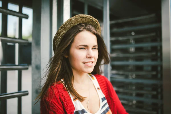 Hermosa joven sonriendo, es feliz, feliz en un sombrero, una camisa roja sobre la ciudad —  Fotos de Stock