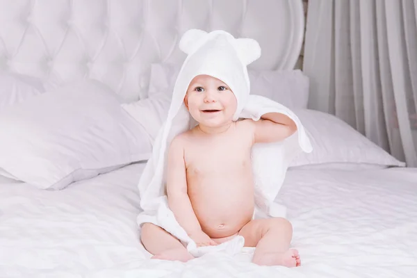 Adorabilmente il bambino si trova su un asciugamano bianco a letto. Infanzia felice e concetto di assistenza sanitaria . — Foto Stock