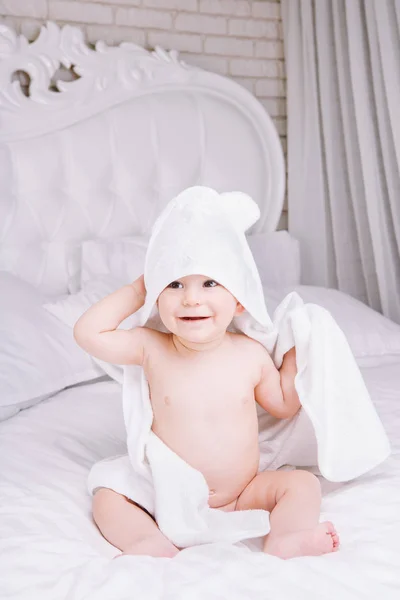 Adorablemente el bebé se acuesta sobre una toalla blanca en la cama. Feliz infancia y concepto de salud . — Foto de Stock