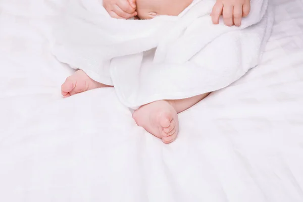 Adoravelmente bebê mentir sobre toalha branca na cama. Infância feliz e conceito de saúde . — Fotografia de Stock