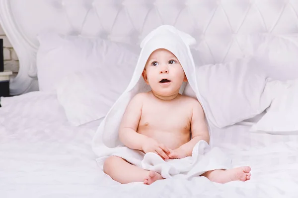Adorably yalan yatakta beyaz havlu üzerine bebeğim. Mutlu çocukluk ve sağlık kavramı. — Stok fotoğraf