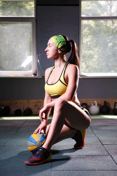 Hermoso, fuerte, delgado, en buena forma física en el gimnasio haciendo ejercicios. Vestido con pantalones cortos y camiseta verde,. Tema deportivo —  Fotos de Stock