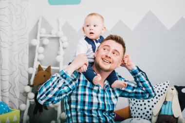 Babası omuzlarında oğlu tutar.