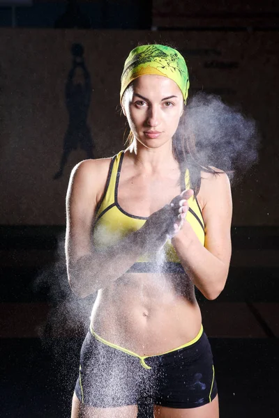 Modelo de fitness femenino aplaudiendo manos con talco en polvo en un gimnasio justo antes de hacer ejercicio . — Foto de Stock
