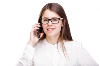 Bir cep telefonu üzerinde konuşurken beyaz izole arka plan üzerinde beyaz bir gömlek güzel genç kız. Gülümsüyor portre bel