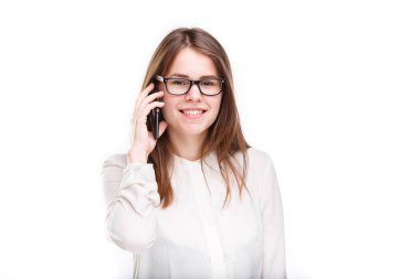 Bir cep telefonu üzerinde konuşurken beyaz izole arka plan üzerinde beyaz bir gömlek güzel genç kız. Gülümsüyor portre bel