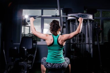 Arkadan Görünüm eğitimli bir kızın egzersizleri yapıyor. Sırt kasları için eğitim