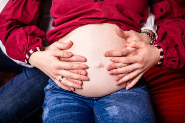 Ojciec posiada swoją ciężarną żonę za rękę. Szczelnie-do góry — Zdjęcie stockowe