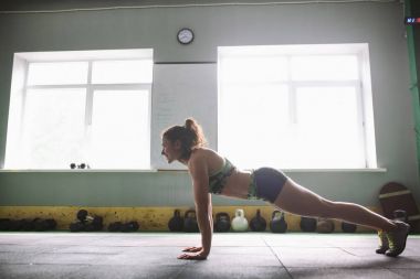 Güzel bir kız eller, geri ve prema hafif windows arka plan üzerinde spor salonunda kasları eğitim için yerden şınav mı