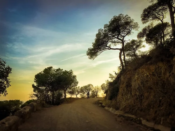 Ciclista uomo in sella a una mountain bike al tramonto montagna tibidabo in Spagna città di Barcellona — Foto Stock