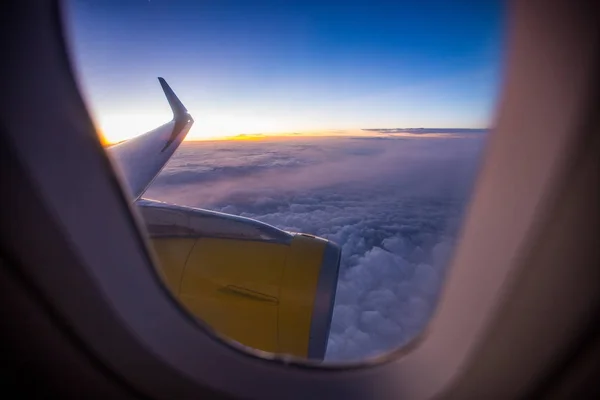 Uitzicht op de zonsondergang op wolk door het raam van het vliegtuig — Stockfoto