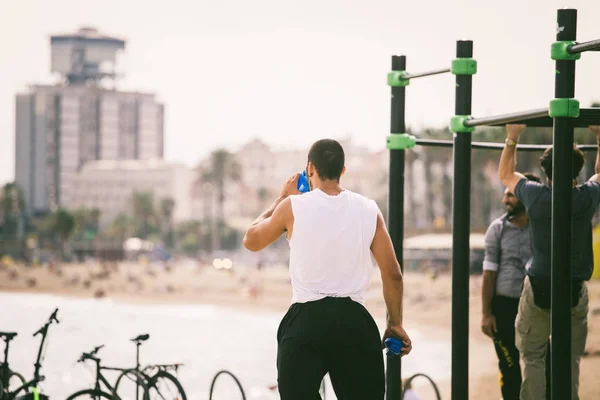 Exercise in the open air in the gymnasium on the beach barceloneta on the shores of the Mediterranean Sea in Catalonia — Stock Photo, Image