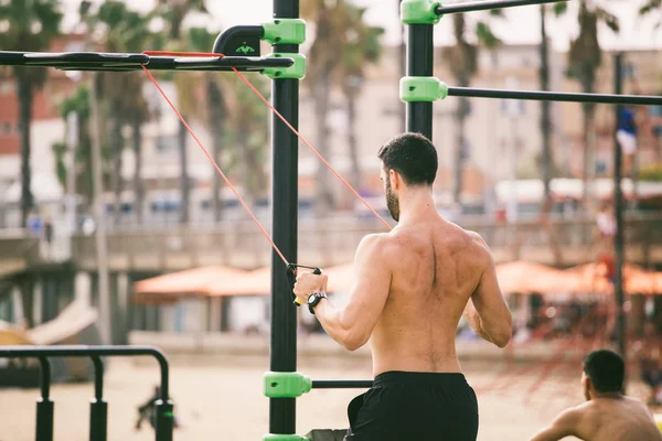 Exercise in the open air in the gymnasium on the beach barceloneta on the shores of the Mediterranean Sea in Catalonia — Stock Photo, Image