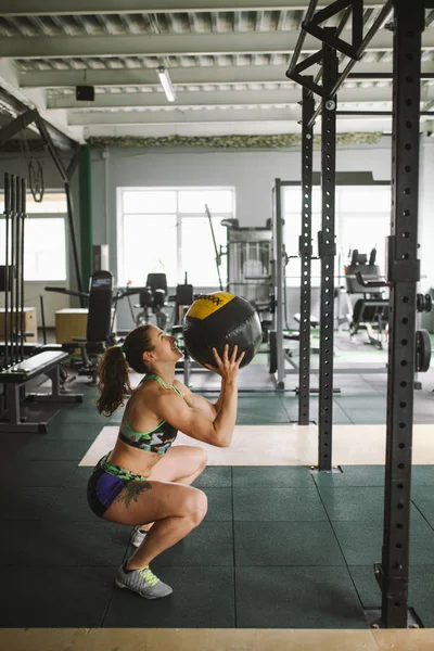 sağlıklı kız bacaklar ve topu jimnastik salonu ile el kasları egzersizleri yapıyor