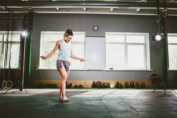 Jovem branca sorrindo mulher segurando uma corda pulando - Conceito de saúde e fitness — Fotografia de Stock