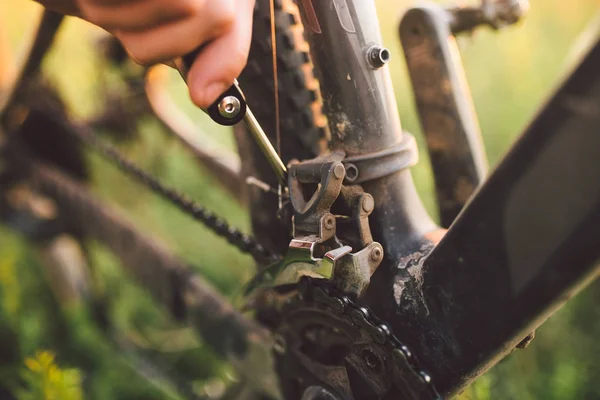 Hand med en cykel redskap var engagerad i fastställande cykel utomhus i solnedgången — Stockfoto