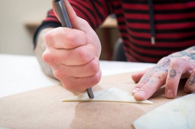 Erkekler ellerini bir metal cam kesme kalıbı olarak cam kesmek