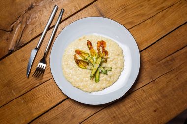 bir restoranda ahşap bir masa üzerinde sebzeli risotto