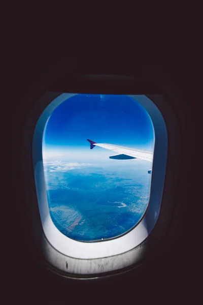 Patrząc przez okno statku powietrznego podczas lotu w skrzydle niebieski niebo — Darmowe zdjęcie stockowe