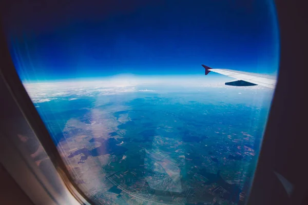 Κοιτάζοντας μέσα από το παράθυρο αεροσκαφών κατά τη διάρκεια πτήσης στην πτέρυγα μπλε ουρανό — Φωτογραφία Αρχείου