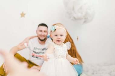 Bir grup genç insan, baba ve annenin 30 yıllık bir aile ve bir yıl, bir kızı bir ışık iç Sit ahşap bir zemin, bir arka plan beyaz duvar ve yapay kar evler.