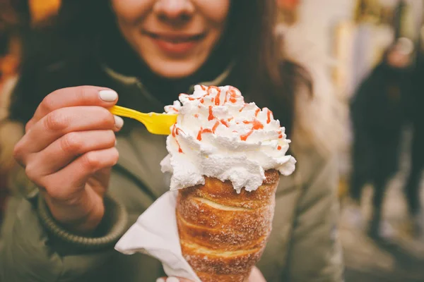 trdelnik veya Trdlo bir güzel kış kız Çek Cumhuriyeti, Prag Zirvesi'nde Noel pazarı elinde krema ile