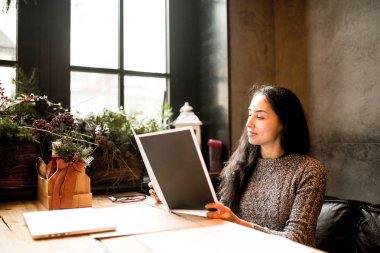 ahşap masa, bulutlu kış gününde Restoran menüde eğitim iş kız Noel décor.sits pencerenin yakınındaki süslenmiş. Sıcak gri Kazak giymiş. Tablo, telefon ve gözlük