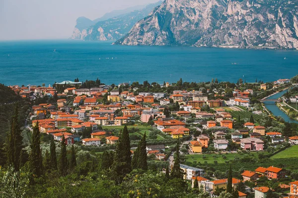 Wunderschöner panoramablick auf einen bergsee in norditalien in der lombardie des lago di garda aus der perspektive. Blick auf die Dächer der Stadt und den Kanal des Riva del Garda im Sommer — Stockfoto