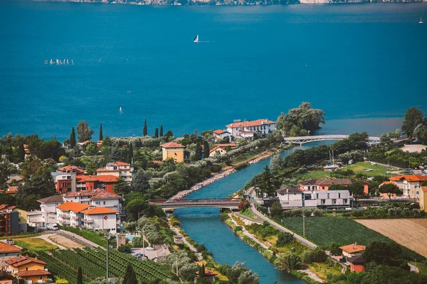 Wunderschöner panoramablick auf einen bergsee in norditalien in der lombardie des lago di garda aus der perspektive. Blick auf die Dächer der Stadt und den Kanal des Riva del Garda im Sommer — Stockfoto