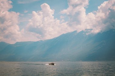 dağlar ve bulutlar fon karşı İtalya Gölü lago di garda üzerinde hızlı motorlu bir tekne yelken. Yaz aylarında güneşli hava