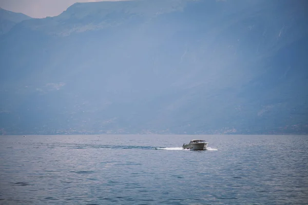 Szybkie motorówki żagle na jezioro lago di garda we Włoszech na tle gór i chmury. Latem w słoneczne dni — Zdjęcie stockowe