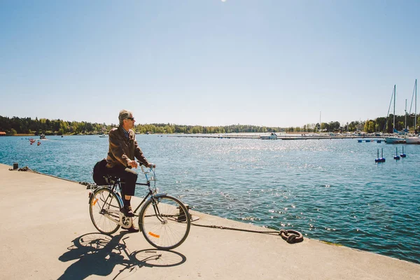 17 Nisan 2014. Nynäshamn İsveç'te şehri. Baltık Denizi çıkabilir. Yatak, otopark ve tekneler, gemiler. Bir adam bir bisiklet üzerinde görünümü hayran — Stok fotoğraf