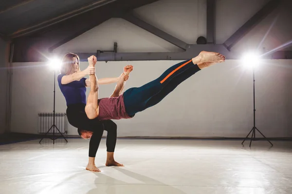 Тема Acroyoga і пози йоги. Acroyogis практики. зі студією підсвічування. Жінка бази тримає людини Flyer в горизонтальному положенні статичні позах — стокове фото