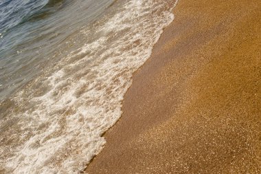 Plaj tatil ve Turizm kavramı. Arka plan dalga deniz sarı kum üzerinde köpük close-up. Akdeniz'de İspanya