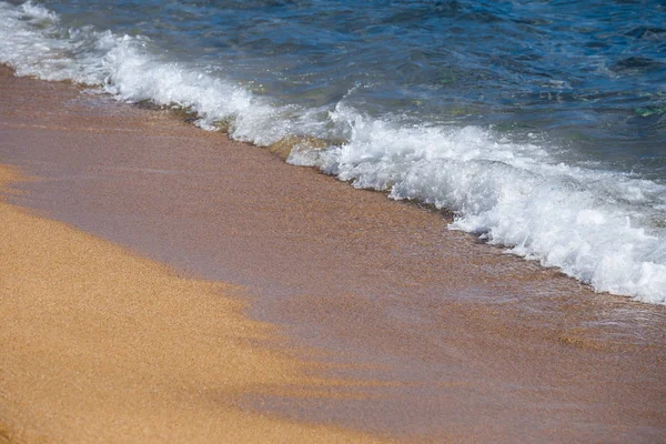 Plaj tatil ve Turizm kavramı. Arka plan dalga deniz sarı kum üzerinde köpük close-up. Akdeniz'de İspanya