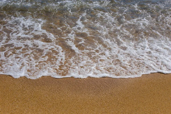 Plaj tatil ve Turizm kavramı. Arka plan dalga deniz sarı kum üzerinde köpük close-up. Akdeniz'de İspanya