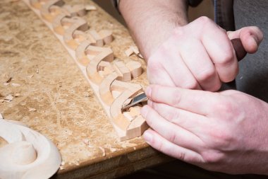 woodcarver mobilya süsleme oluşturur. Woodcarver'ın elleri, keski, araçlar, oyulmuş ağaçtan süsleme.